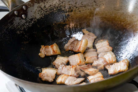 Sliced pork belly stir fried in a hot wokの写真素材