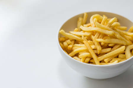 Full bowl of french fries on a white backgroundの写真素材