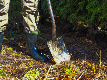 a man with a shovel working in the garden