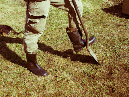 a man with a shovel working in the garden