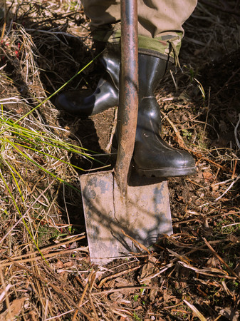 a man with a shovel working in the garden