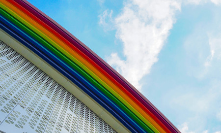 rainbow colored building and sky with cloudsの写真素材