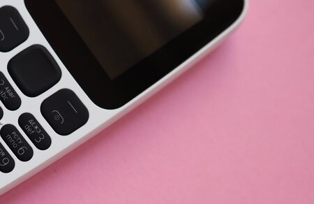 old model cell phone on pink background