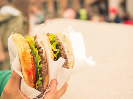 very big hamburger in his hand. fast foodの写真素材