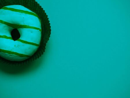 glazed donut lies on a monophonic background