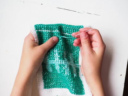 hands embroidering pattern close-up on white background needlework