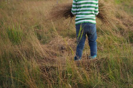 a child plays in a field with hayの写真素材