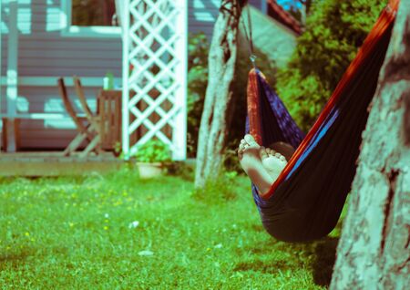 girl resting lying in a hammock in the summer garden