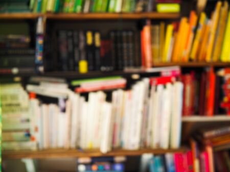 blurry image of a shelf with lots of brightly colored booksの写真素材