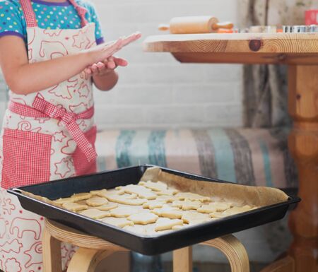 a child at home cuts out cookie cutters