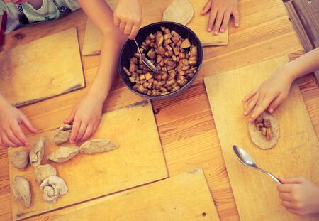 children work together to roll out dough for bakingの写真素材