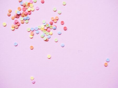 colorful confetti scattered on a light backgroundの写真素材