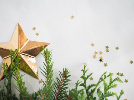 Christmas background. green spruce twigs with gold ribbon lie on a white backgroundの写真素材