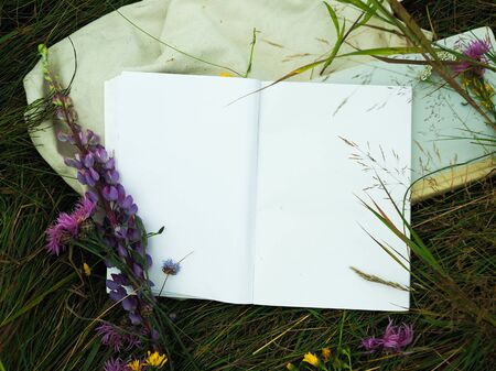open an empty notebook on the background of grass and flowersの写真素材