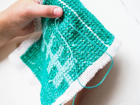 hands embroidering pattern close-up on white background needleworkの写真素材