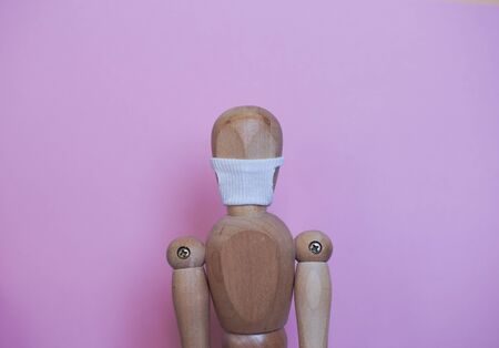 wooden mannequin in the mask from the coronavirusの写真素材
