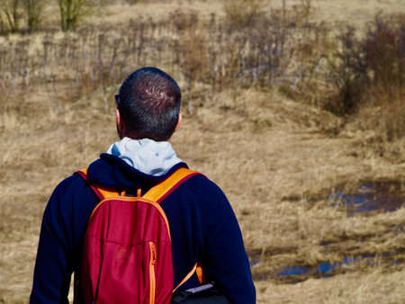 Young tourist went on a trip to the world ,man in a rapeseed field with a backpack ,hiking .man, model High quality photoの写真素材