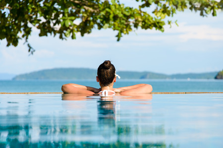Relax and spa concept. Woman with a flower in hair relaxing in a pool at Krabi, Thailand. Relax and spa concept. Woman with a flower in hair relaxing in a pool at Krabi, Thailand.