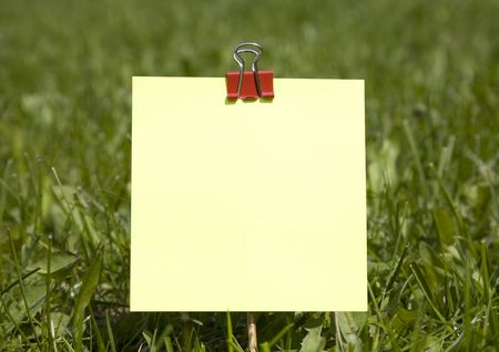 Yellow Note On Green Grass Backgroundの写真素材