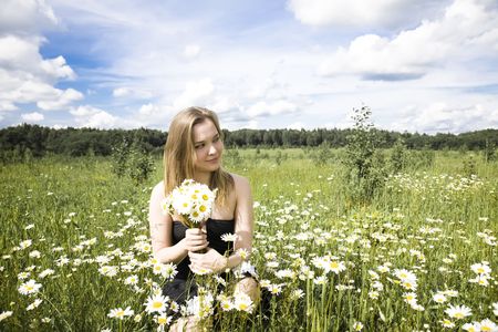 Young Woman With Flowers Relaxing Outdoorsの写真素材