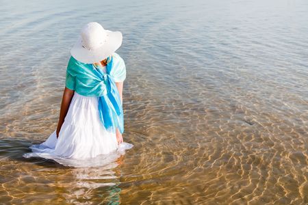 Young woman in white dress sitting in the waterの写真素材