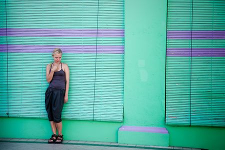 Thinking beauty woman against old green city wallの写真素材