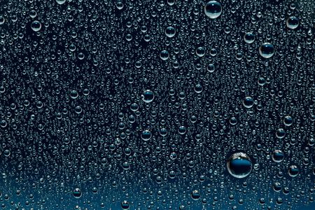 Water drops on a dark blue glass surface. Nature collection.の写真素材