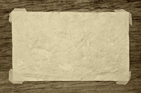 Old grunge paper on the dark wood backgroundの写真素材