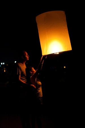 Hua Hin, THAILAND - NOVEMBER 21: Two people holding a flying fire lantern to celebrate the Loy Krathong festival. November 21, 2010 in Hua Hin, Thailand.のeditorial素材
