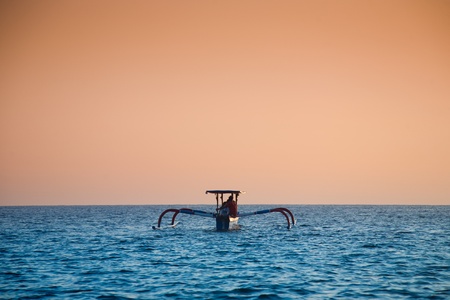 Traditional balinese fishing boat at dawnの写真素材
