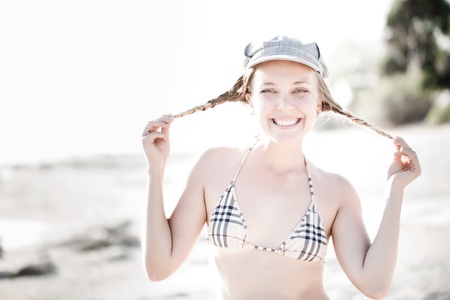 Happy woman playing with hair on seafrontの写真素材