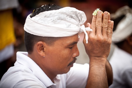 UBUD, BALI, INDONESIA- JULY 16: Unidentified men praying  at the Balinese Temple during the Kuningan Festival  on July 16, 2011 in Ubud, Bali, Indonesia.のeditorial素材