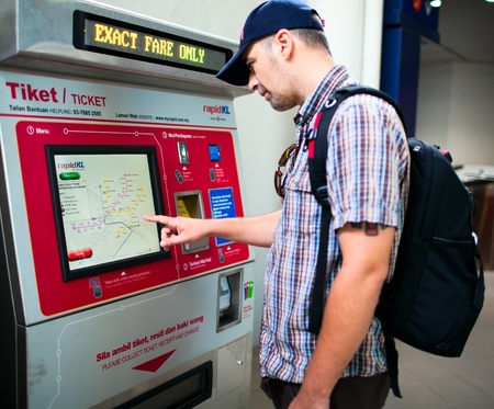 KUALA LUMPUR - NOVEMBER 29: Passenger purchasing metro ticket in automatic machine. November 29, 2011 in Kuala Lumpur, Malaysia. のeditorial素材