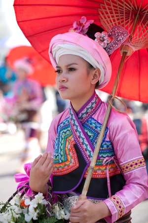 CHIANG MAI, THAILAND - FEBRUARY 4: Traditionally dressed smiling ypong woman under umbrella on Chiang Mai 36th Flower Festival on February 4, 2012 in Chiang Mai, Thailandのeditorial素材