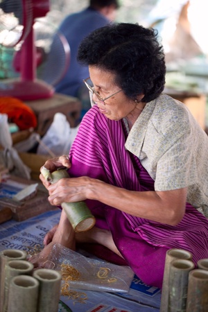 CHIANG MAI, THAILAND - FEBRUARY 5: Woman making a wooden umbrella in traditional umbrella factory on February 5, 2012 in Chiang Mai, Thailandのeditorial素材