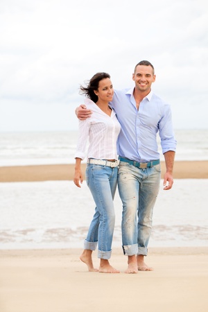 Happy young couple enjoying a solitary beachの写真素材