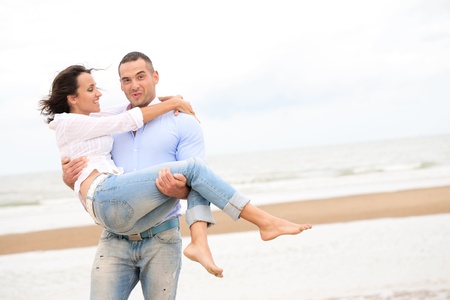 Portrait of a happy young couple at the sea shore の写真素材