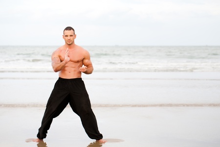 Man training karate at the beachの写真素材