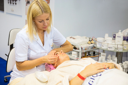 MOSCOW - OCTOBER 24: Cosmetologist performs a facial massage at the international exhibition of professional cosmetics and beauty salon equipment INTERCHARM on October 24, 2014 in Moscowのeditorial素材
