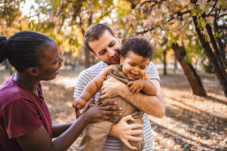Boy in the arms of his parents in the park