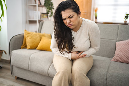 Woman experiencing painful stomachache at home