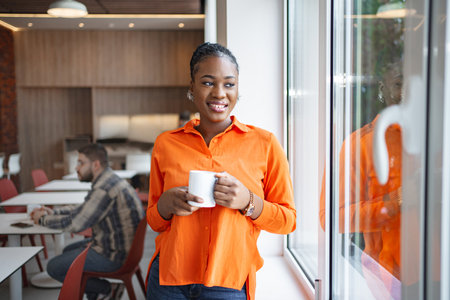 Woman in Orange Shirt Holding Coffee Cup