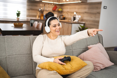 Woman with wireless headphones having fun playing video games at home