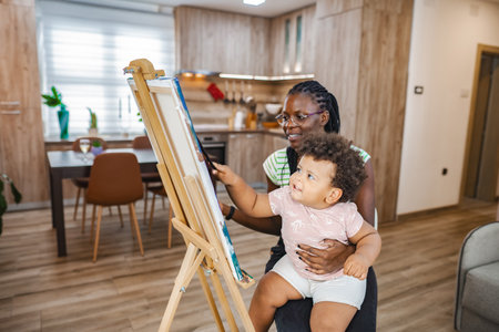 Mom and child bond while painting indoorsの写真素材