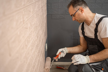 Man Painting Wall With Paint Rollerの写真素材