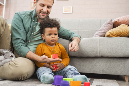 Multiracial family playing with colorful building blocks at homeの写真素材