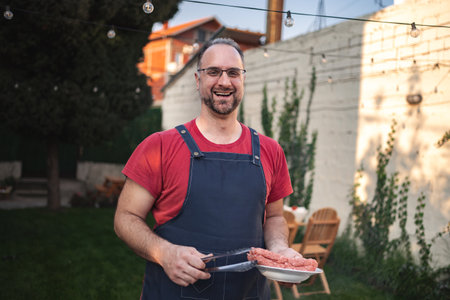 Joyful chef preparing fresh ingredients for a backyard barbecue gatheringの写真素材