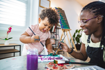 Creative bonding as a child explores painting with joyの写真素材