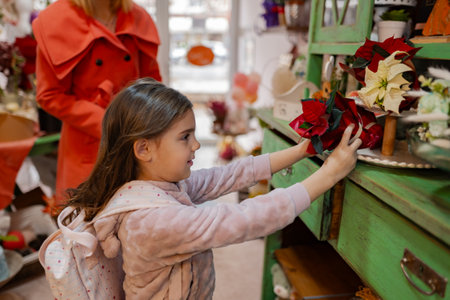Little girl explores colorful flowers while shopping in a charming local store during autumnの写真素材