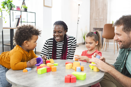 Multiracial family engaging in playtime with colorful blocks indoorsの写真素材